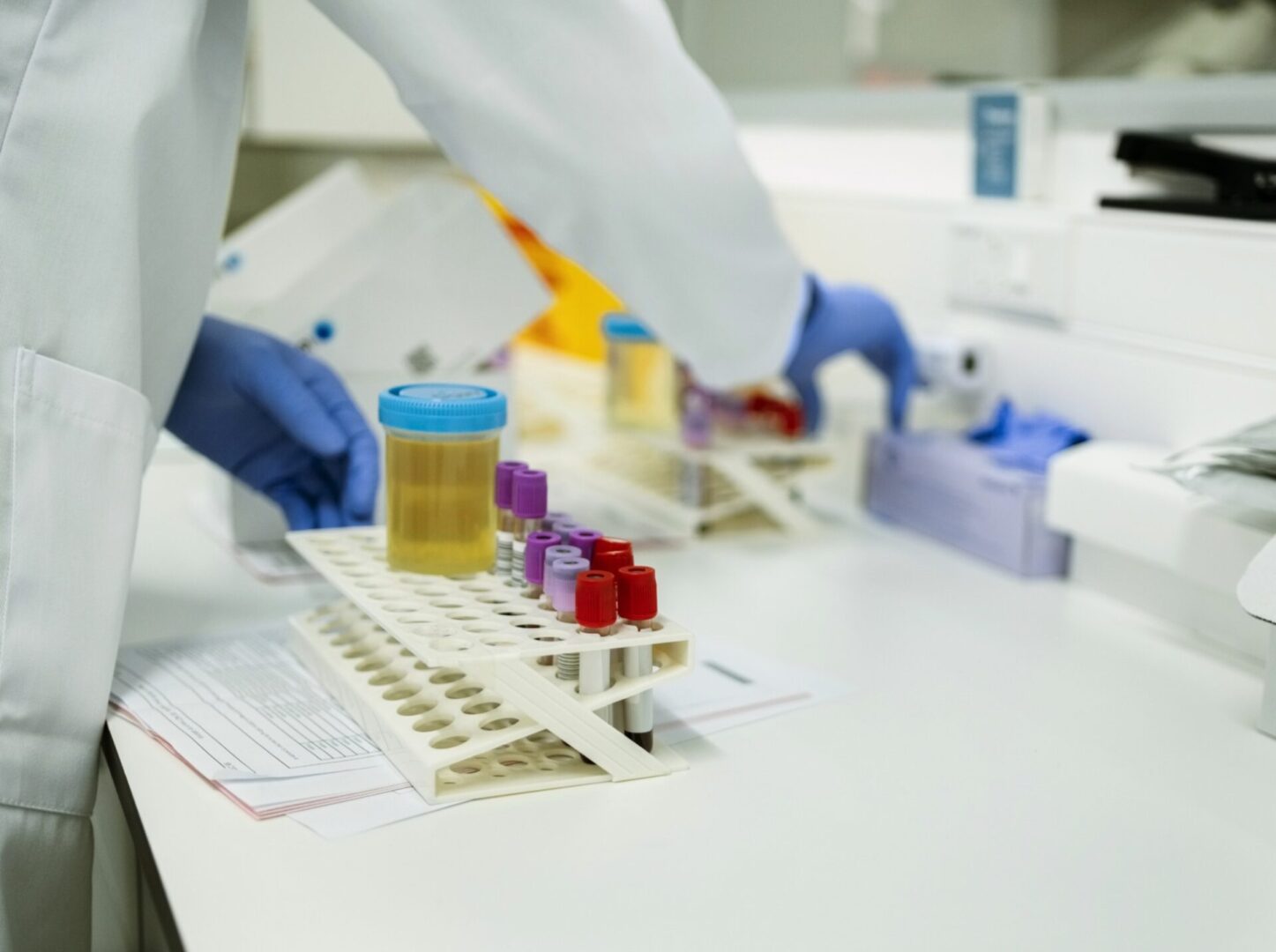 Lab technician handling test tubes and samples.
