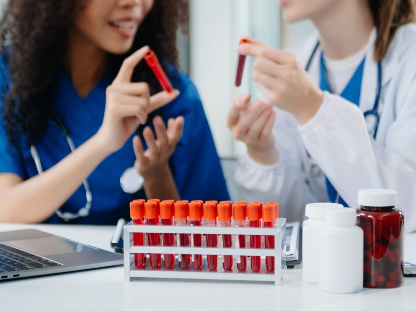 Medical professionals examining blood samples in lab.