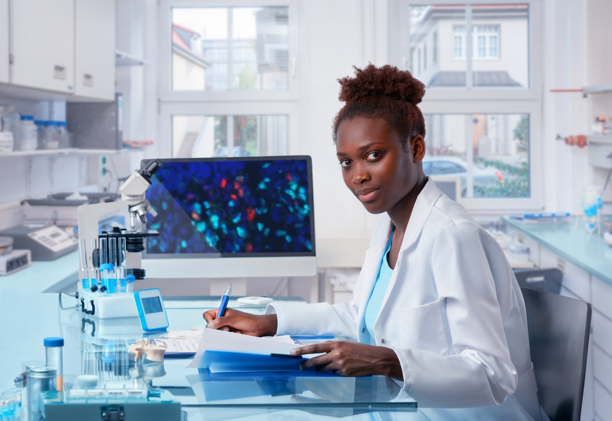 Scientist working in a laboratory, taking notes.